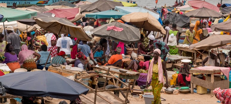 Mbour, Senegal - July, 2014: Several hundred people come together at the local fish market in Mbour to buy and sell the daily catch from the fishermen on July 9, 2014 in Mbour, Senegal.