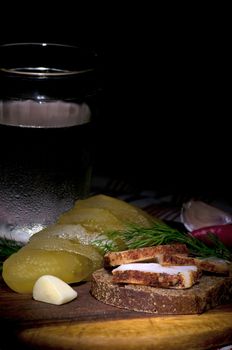 Sandwich with spiced lard served with garlic, pickled cucumber and vodka