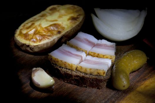 Sandwich with salted lard, served with onion, cucumber and garlic