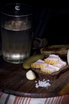 Sandwich with salted lard served with onion, cucumber, garlic and misted glass of vodka