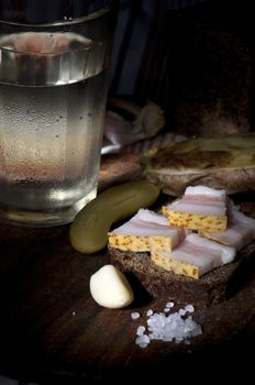 Sandwich with salted lard served with onion, cucumber, garlic and misted glass of vodka