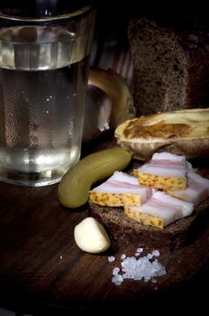 Sandwich with salted lard served with onion, cucumber, garlic and misted glass of vodka