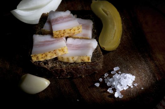 Sandwich with salted lard, served with onion, cucumber and garlic