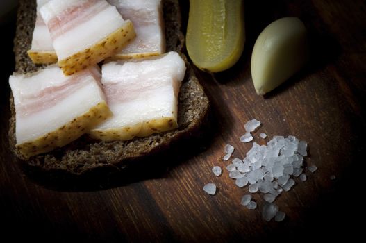 Sandwich with salted lard, served with onion, cucumber and garlic