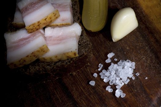 Sandwich with salted lard, served with onion, cucumber and garlic