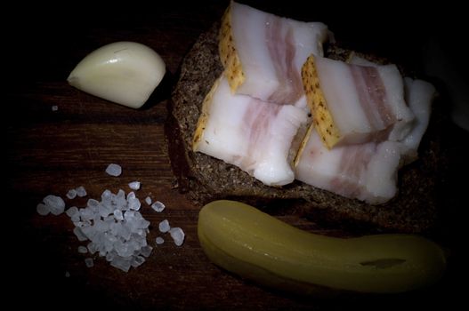 Sandwich with salted lard, served with onion, cucumber and garlic