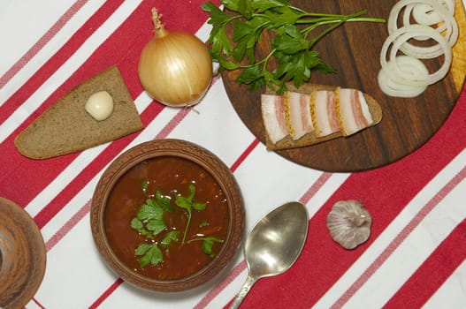 Traditional Ukrainian soup in pottery served with salted lard on rye bread