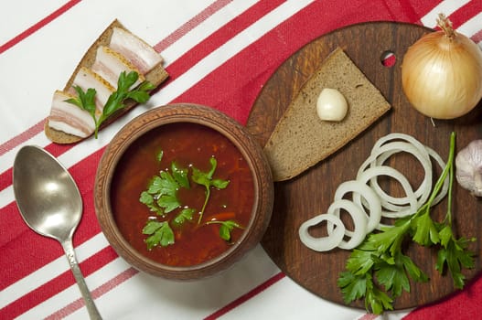 Traditional Ukrainian soup in pottery served with salted lard on rye bread