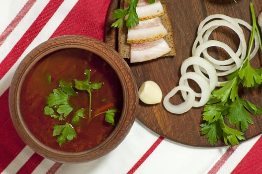 Traditional Ukrainian soup in pottery served with salted lard on rye bread