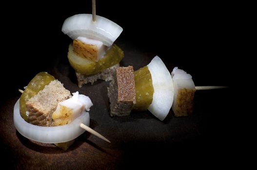 Canape with salted lard, onion, pickled cucumber and rye bread