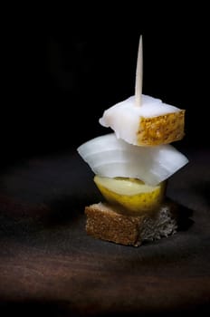 Canape with salted lard, onion, pickled cucumber and rye bread