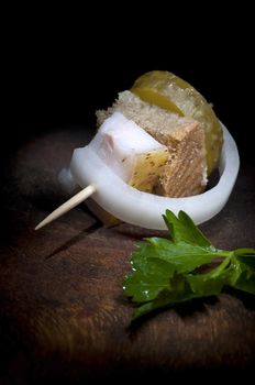 Canape with salted lard, onion, pickled cucumber, rye bread and parsley