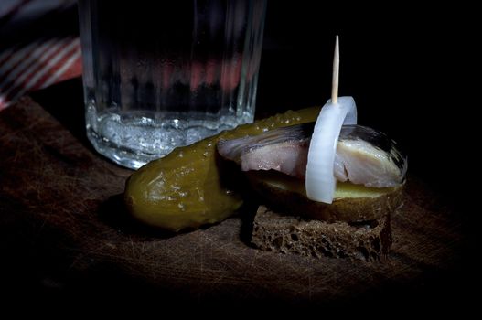 Sandwich made of herring on boiled jacket potato and rye bread served with vodka