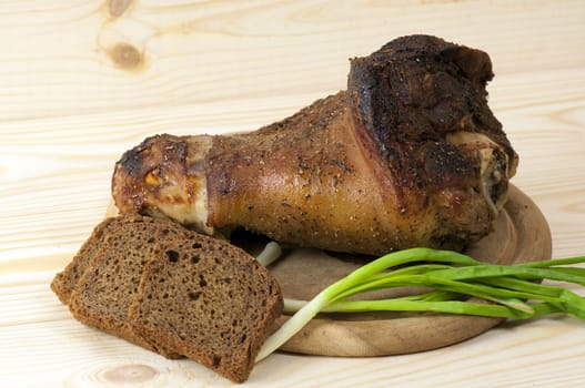 Roasted pork leg served with green onion and rye bread
