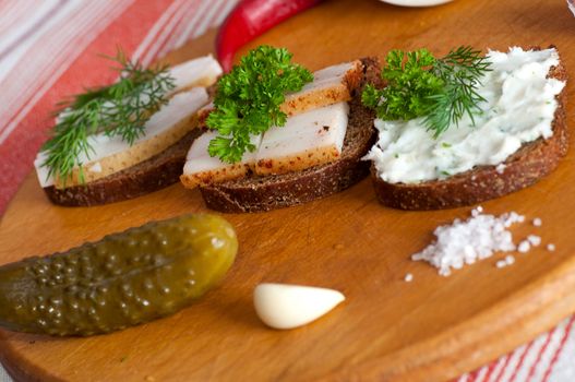 Sandwiches with salted, spiced and spread lard served with onion, garlic and red pepper