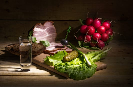 Still life with vodka, black bread, bacon and herbs