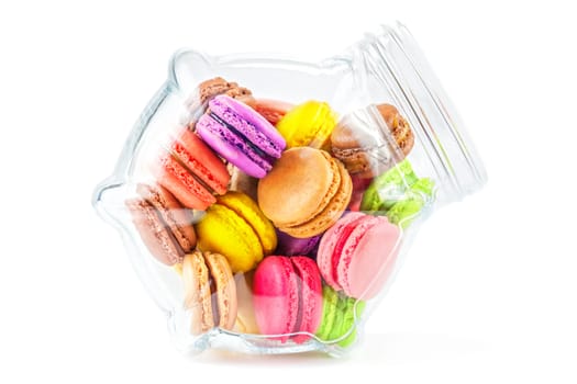 traditional french colorful macarons in a glass jar on white background