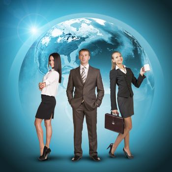 Business people in suits standing on background of Earth. World map on dark background. Elements of this image furnished by NASA