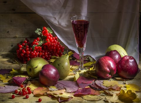 autumn still life with apple, pear, cranberry, fallen leaves glass of wine