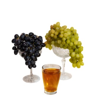 bunch of white and black grapes and a glass of grape juice isolated on white