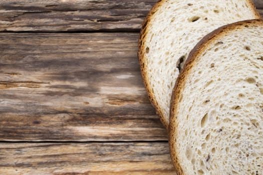 Slices of bread on a wooden background.
