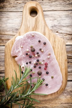 Pork chop, meat slices  on a wood background.