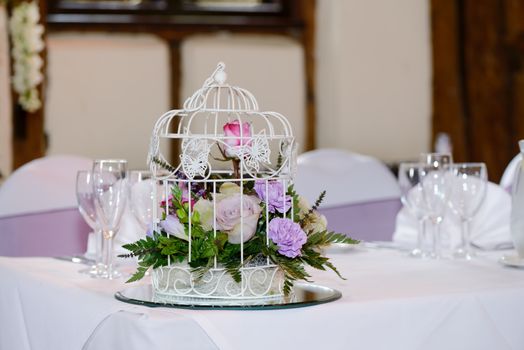 Wedding reception decoration is flowers in cage decorated with butterflys