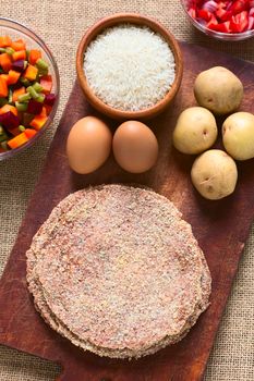 Traditional Bolivian meat called Silpancho, which is a breaded flat, round piece of beef meat, served with fried egg, rice, fried potatoes and vegetables (carrot, bean, beetroot), photographed with natural light 