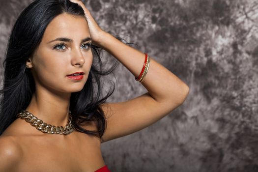 Close up Pretty Young Woman with long Black Hair, Wearing Red. Looking at Right Frame. Captured with Abstract Brown Background.