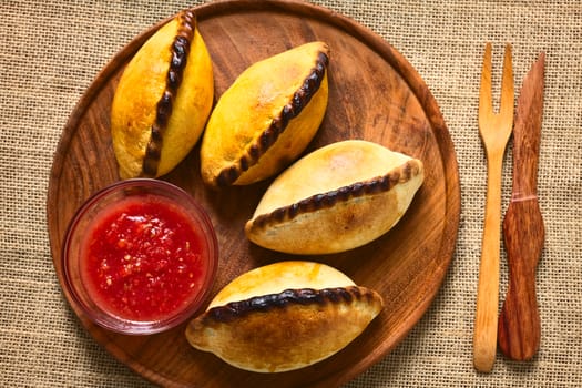 Overhead shot of traditional Bolivian savory pastries called Saltena filled with thick meat stew, which is a very popular street snack in Bolivia photographed with natural light 