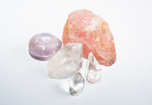 Quartz rocks. Group of semi-precious quartz, amethyst, rose quartz, pointed crystals on white background.