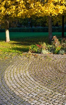 Cobble stone pattern and yellow leaves. Autumn in Vallingby, Stockholm, Sweden.