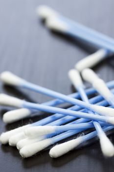 Random pile of blue plastic cotton ear buds for cleaning wax out of the ear in a health and hygiene concept