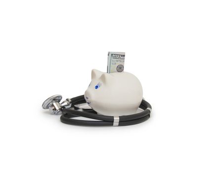 Pink piggy bank with stethoscope