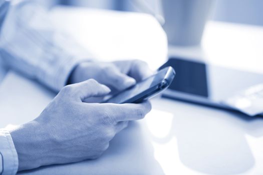 Hands of woman sending SMS via smartphone at lunch