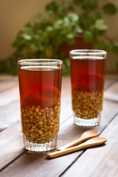 Traditional Chilean non-alcoholic cold drink called Mote (cooked husked wheat) con Huesillo (dried peach). The beverage is prepared by cooking the dried peach with sugar and cinnamon in water. (Selective Focus, Focus on the first drink)  