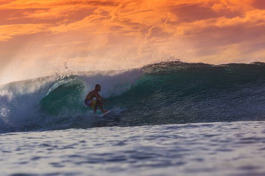 Surfer on Amazing Wave at sunset time, Bali island.