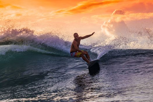 Surfer on Amazing Wave at sunset time, Bali island.