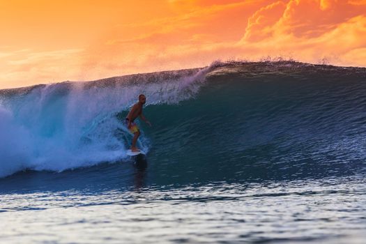 Surfer on Amazing Wave at sunset time, Bali island.