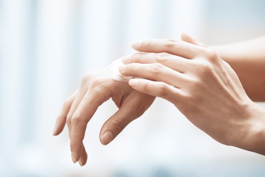 Woman applying moisturizing cream on hands