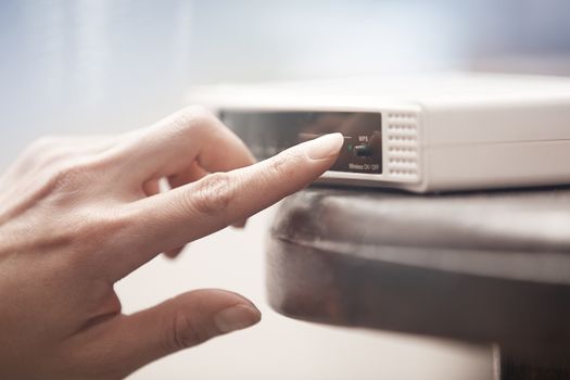 Human hand turning on wireless modem. Close-up horizontal photo