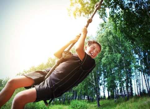 Vignetting Photo of Kid Bungee jumping in the Summer Forest