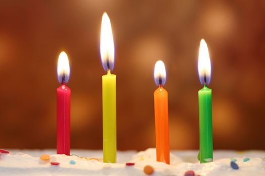 Four lit birthday candles close up, shallow dof