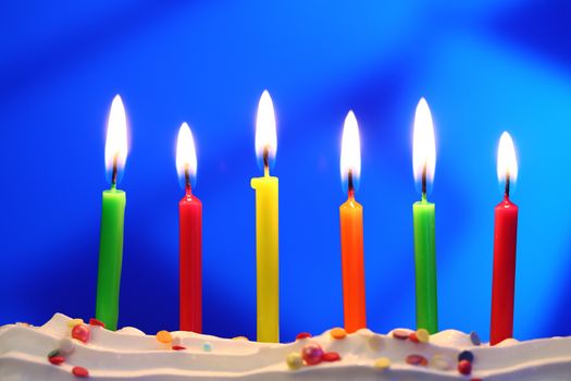 Six lit birthday candles close up, shallow dof