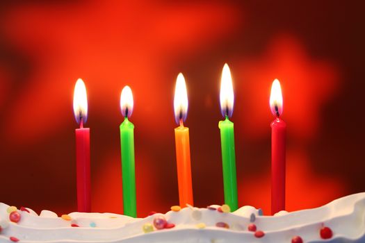Five lit birthday candles close up, shallow dof