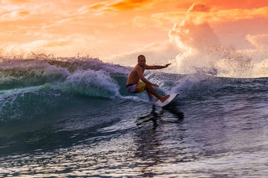 Surfer on Amazing Wave at sunset time, Bali island.