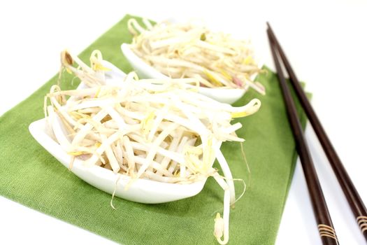 fresh mung bean sprouts with chopsticks on a light background