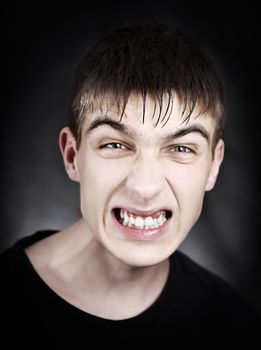 Toned Portrait of Angry Young Man on the Black Background