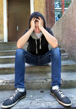 Sad Teenager on the landing steps of the Old House