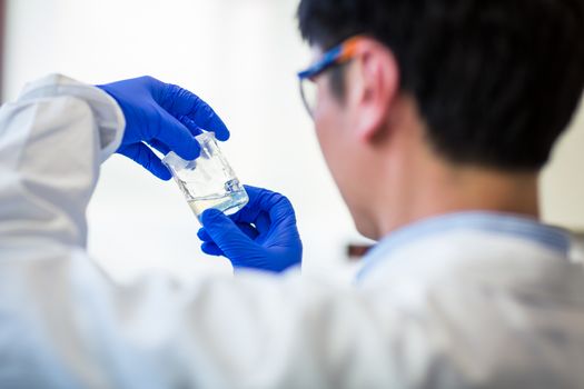 Male researcher carrying out research in a chemistry lab (color toned image; shallow DOF)